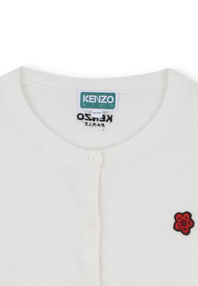 White knitted cardigan with round neckline, four buttons, and a red embroidered flower detail on the left chest. Brand tag visible.