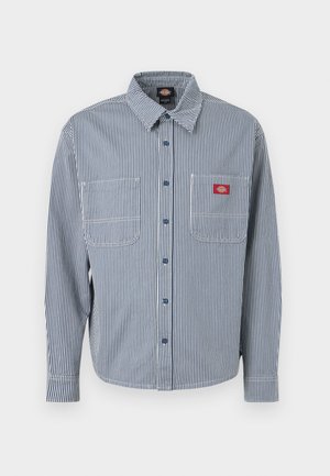 Langärmeliges Hemd zum Knöpfen mit blauen und weißen vertikalen Streifen, zwei Brusttaschen und einem roten Logoaufnäher auf der linken Tasche.