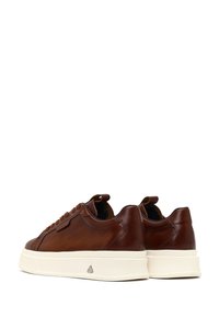 Sneakers in pelle marrone con suole in gomma color crema, forma arrotondata, lacci a contrasto e pannello laterale testurizzato. Parte posteriore con linguetta.