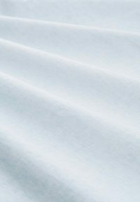 Tissu de culoare albastru deschis cu o textură netedă, având pliuri moi și un luciu subtil. Suprafața pare uniformă și uniformă, fără modele.