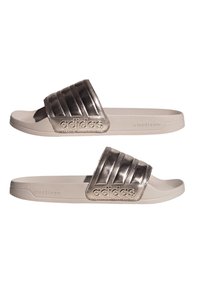 Chanclas Adidas con una correa metálica plateada que presenta tres estrías horizontales, una base beige claro y acolchado Cloudfoam para mayor comodidad.