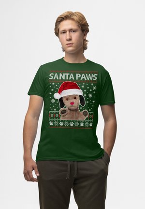 Grøn bomulds t-shirt med et grafisk motiv af en hund i en julesok, omgivet af snemænd og teksten "SANTA PAWS" i hvid og rød.