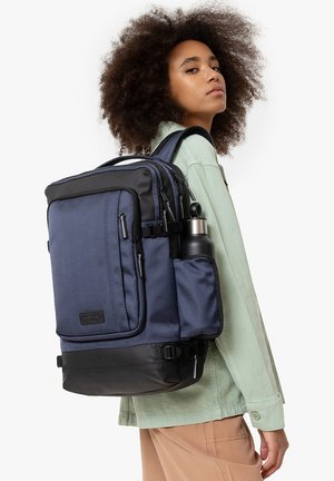 Navy blue backpack with textured fabric, black accents, multiple compartments, water bottle holder, and padded straps for comfort.