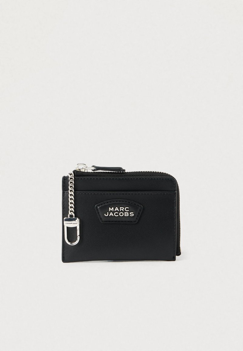 Μαύρο δερμάτινο πορτοφόλι με φερμουάρ, ασημένια �αλυσίδα και λογότυπο στο μπροστινό μέρος. Συμπαγές σχέδιο, ελάχιστη υφή.