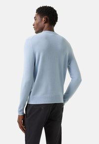 Hellblauer Pullover aus weichem Material, mit geripptem Ausschnitt und Ärmelbündchen, anliegende Ärmel und abgerundetem Saum.