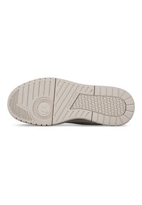 Suola della scarpa in beige chiaro, con motivi di grip testurizzati e un elemento logo circolare. Il design enfatizza la trazione e la durata.
