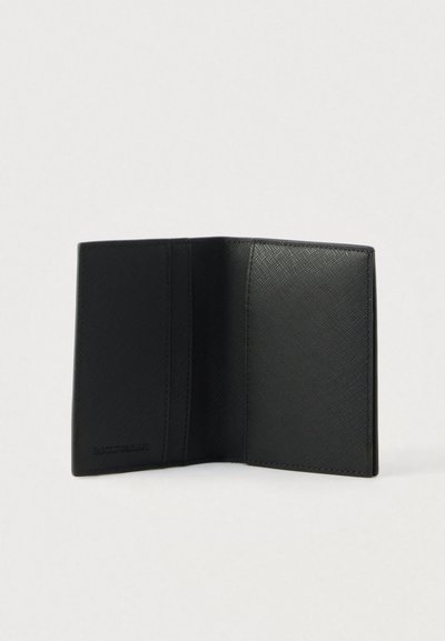 Fekete, texturált bőr kétoldalas pénztárca nyitva, belső kártyatartók és rekeszek láthatók egyszínű világos háttéren.