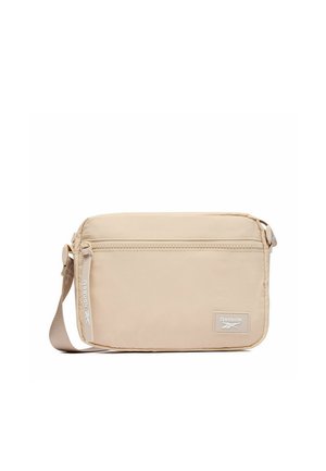 Borsa a tracolla rettangolare beige con tasca frontale con zip, tracolla in tessuto regolabile e patch con logo Reebok nell'angolo in basso a destra.