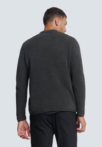 Dunkelgrauer Pullover aus Strickstoff mit rundem Halsausschnitt, langen Ärmeln und lockerem Schnitt mit gerippten Bündchen und Saum.