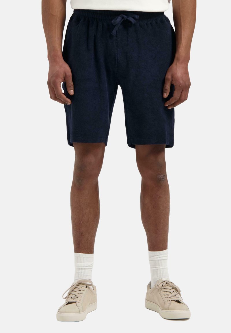 Marineblå shorts med elastisk liv og snor, laget av mykt stoff. Har side lommer og en avslappet passform, som slutter over kneet.