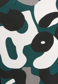 Conception abstraite mettant en avant des formes teal, noir, gris et blanc avec une finition texturée, affichant des formes organiques audacieuses et des motifs chevauchants.