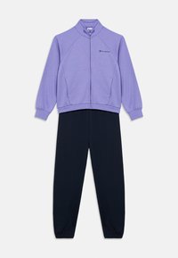 Μωβ ζακέτα με φερμουάρ και γιακά, σε συνδυασμό με μαύρο παντελόνι. Διαθέτει μανίκια ράγκλαν, ελαστικά μανσέτες και ένα μικρό λογότυπο στη ζακέτα.