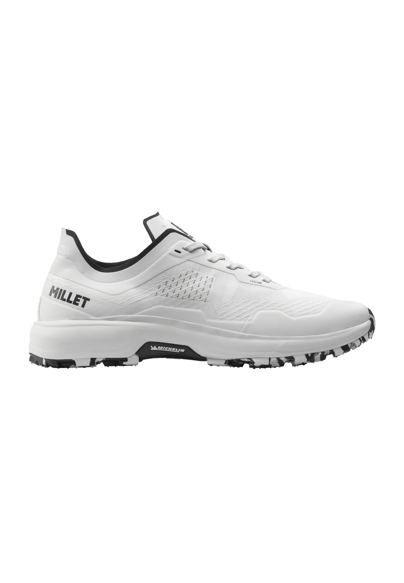 Chaussure de sport blanche avec une tige texturée, des accents noirs et une semelle robuste noire et blanche. Dispose d'un design à lacets. Logo de la marque visible.
