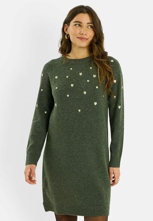 Vestido verde de punto con mangas largas, cuello redondo y patrones metálicos de corazones dispersos. Puños y dobladillo acanalados que añaden textura.