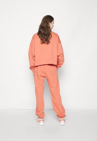 Nike Sportswear W NSW ESSNTL PANT FLC TREND - Calças de fato de treino - madder root/white