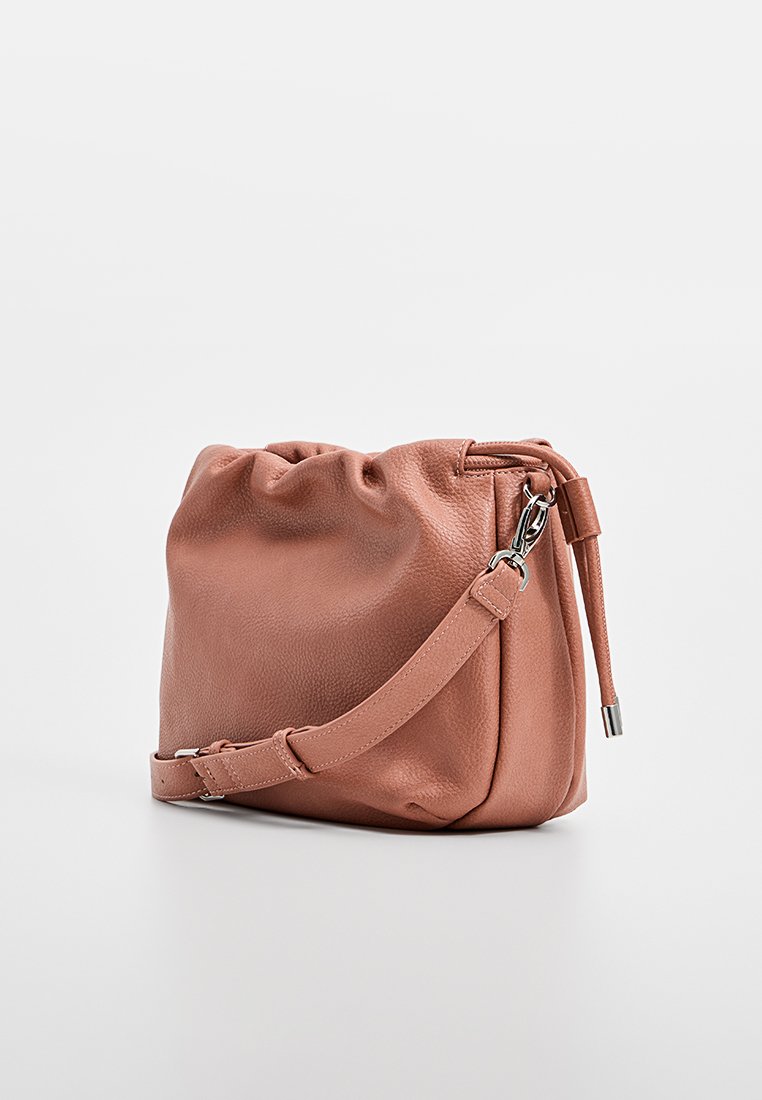 Bolso de hombro de cuero rosa con un acabado texturizado, parte superior anudada, correa ajustable y herrajes en tono plateado. Forma rectangular compacta.