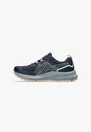 Marineblauwe sportschoenen met een mesh-bovenkant, lichtgroene accenten en een dikke, gestructureerde grijze zool. Voorzien van veters en een trekband aan de hiel.