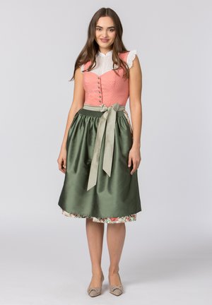 Traditionelles Kleid mit einem Korallen-Oberteil mit Knöpfen, weißen Spitzenbesätzen und einem grünen Satinrock, der mit einem passenden Band gebunden ist. Blumenunterrock.