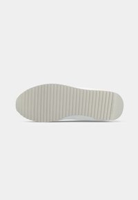 Sole di sneaker bianca con superficie texturizzata, punta semicurva e motivo rigato per la trazione. Presenta un materiale liscio di colore grigio chiaro.