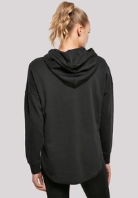 Felpa nera con cappuccio, maniche lunghe, vestibilità comoda e orlo curvo. Tessuto morbido e strutturato con un design semplice.