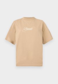 Beige bavlněné tričko s krátkými rukávy, kulatým výstřihem a bílým kurzívním textem vpředu, který zní "Pegador Dreams Come True."