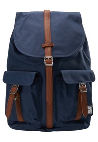 Granatowy plecak z materiału, z brązowymi skórzanymi paskami, dwiema przednimi kieszeniami oraz klapą zapinaną na klamrę. Teksturowany materiał.