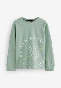 Svijetlozelena majica dugih rukava s kružnim bijelim i žutim logotipom na kojem piše "TED BAKER" i istaknutim dizajnom slova "B" u središtu.