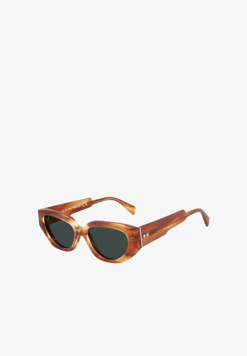 Gafas de sol con una amplia forma de ojo de gato. Fabricadas en un material translúcido de carey marrón con lentes oscuros. Presentan acentos de hardware mínimos.