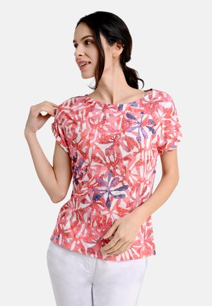 Kurzärmliges Oberteil mit einem lebhaften Blumenmuster in Pink, Rot und Lila. Weicher Stoff mit einem entspannten Bootsausschnitt und umgeschlagenen Bündchen.