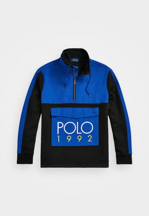 Pull à manches longues bleu et noir avec demi-fermeture éclair, poche à rabat à l'avant, et « POLO 1992 » imprimé en blanc et jaune sur la poche.