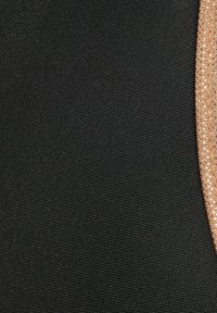 Čierna látka so hladkým povrchom, ktorá obsahuje zlatý kovový akcent spolu s radom malých čírych kryštálov.