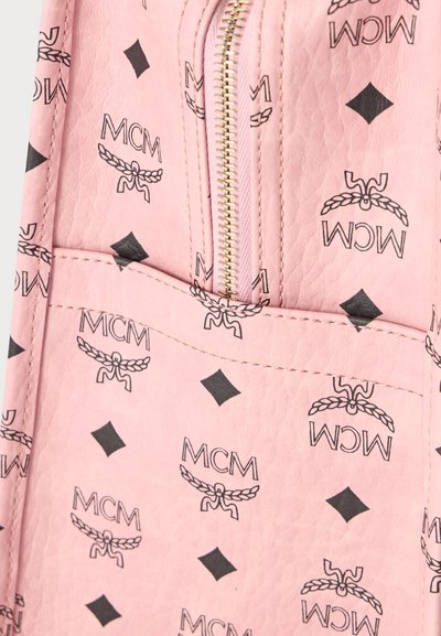 Tissu en cuir texturé rose avec logos MCM noirs et motif d'emblème ailé, comprenant une fermeture éclair dorée et une poche cousue.