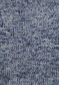 Tejido de punto en diferentes tonos de azul y gris, con un patrón jaspeado texturizado, costuras visibles y fibras de varios tonos.