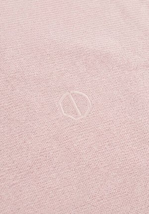 Lichtroze textiel met een subtiel, gegraveerd cirkelvormig logo met een diagonale lijn in het midden.