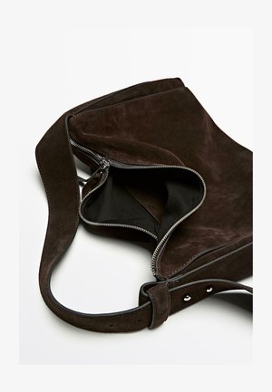 Donkerbruin suede schoudertas met een gedeeltelijk open zilveren rits, brede verstelbare schouderband en een zwarte stoffen voering.