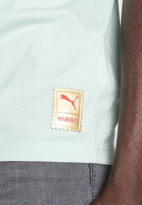 Puma PUMA HARIBO GRAPHIC TEE - Triko s potiskem - gossamer green