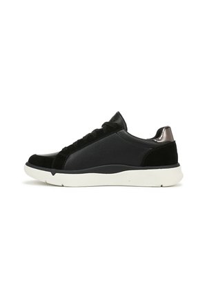 Sneaker nera bassa con chiusura a lacci, suola bianca e dettaglio metallico sul tallone, mostrata di lato su sfondo bianco.