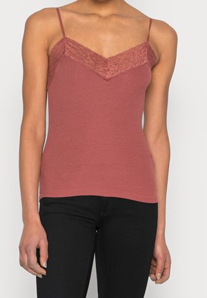 Ribbede tanktop i støvet rosa med en blondekant i halsen. Har justerbare spaghetti stropper og en tætsiddende silhuet.