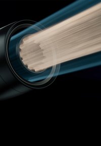 Nahaufnahme eines zylindrischen Geräts, das fokussierte, parallele Lichtstrahlen vor einem dunklen Hintergrund aussendet.