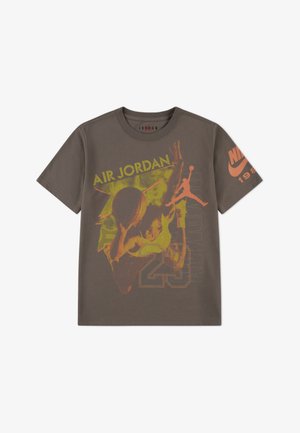 T-shirt marrone a maniche corte con grafica arancione di un giocatore di basket, testo "AIR JORDAN" e logo "NIKE" sulla manica.