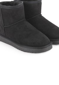 Botas de tobillo de ante negro con punta redonda, detalles cosidos y una suela de goma baja con textura para mayor agarre. Forradas con material suave.