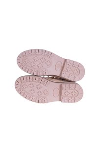 Plantillas de zapatos de goma rosa con un patrón texturizado, que presentan surcos y formas cruzadas para mayor tracción. Superficie lisa sin desgaste visible.