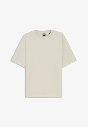 Ljusbeige t-shirt i mjuk bomull, med avslappnad passform, rund hals och korta ärmar. Inga synliga mönster eller detaljer.