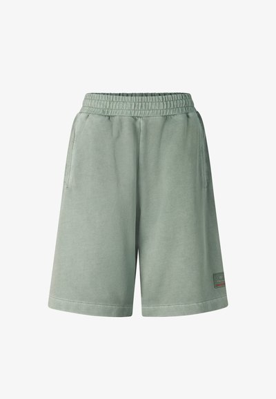 Shorts décontractés vert clair avec une taille élastique, des poches latérales et un petit patch logo rectangulaire près de l'ourlet sur la jambe droite.