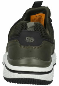 Zapatilla deportiva verde olivo con parte superior de malla, cuello acolchado y suela de goma. Presenta un acento gris y una suela negra con agarre texturizado.