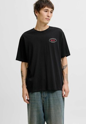 Zwarte katoenen T-shirt met een ronde halslijn en korte mouwen, voorzien van een contrasterende rode graphic op de borst en een losse pasvorm.