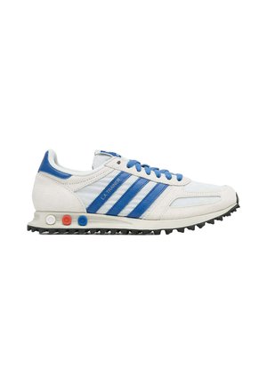 Sneaker Adidas LA Trainer bianca e blu con strisce blu, lacci blu e inserti ammortizzanti colorati sulla suola intermedia.