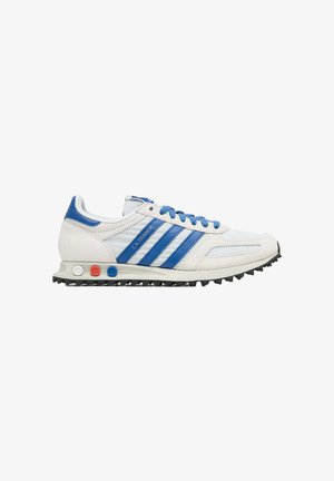 Sneaker Adidas LA Trainer bianca e blu con strisce blu, lacci blu e inserti ammortizzanti colorati sulla suola intermedia.