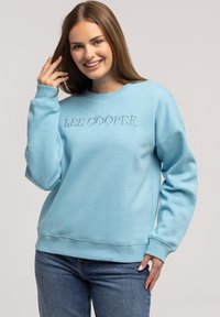 Jasnoniebieska bluza z wytłoczonym napisem "LEE COOPER" z przodu, z okrągłym dekoltem, długimi rękawami oraz ściągaczami przy mankietach i u dołu.