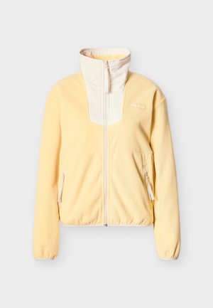 Svetlo rumena volnena jakna z visokim ovratnikom, sprednjo zadrgo, zadrgljivimi stranskimi žepi in logotipom Columbia na levi strani prsnega koša.